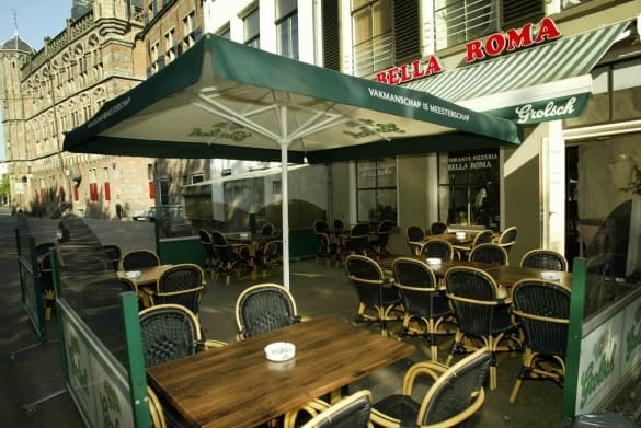 Het terras onder de groen met witte parasol aan de Brink