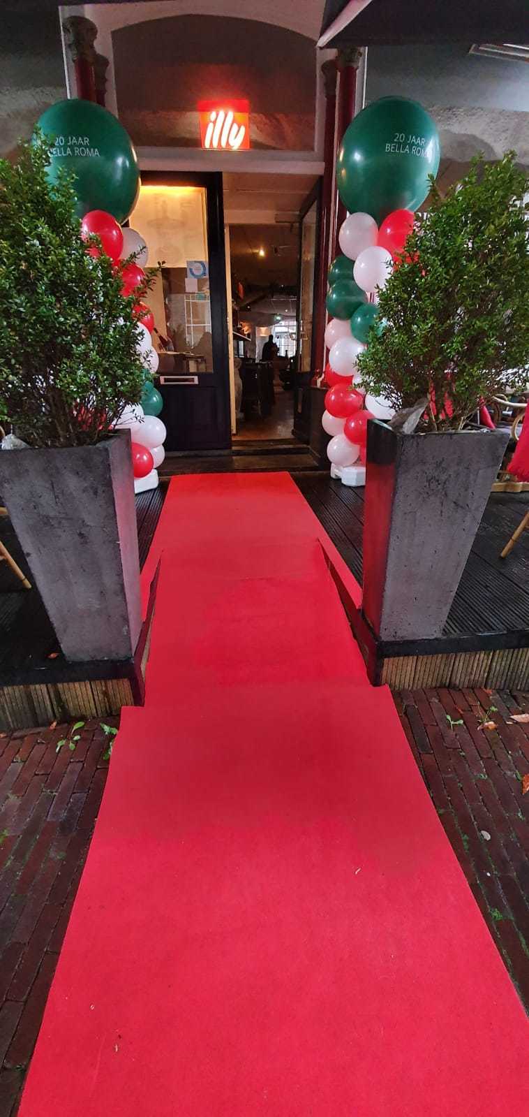 De rode loper naar de ingang, tussen ballonnen in groen, wit en rood