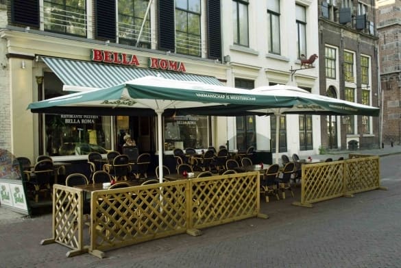 De gevel van Bella Roma aan de Brink met het terras ervoor