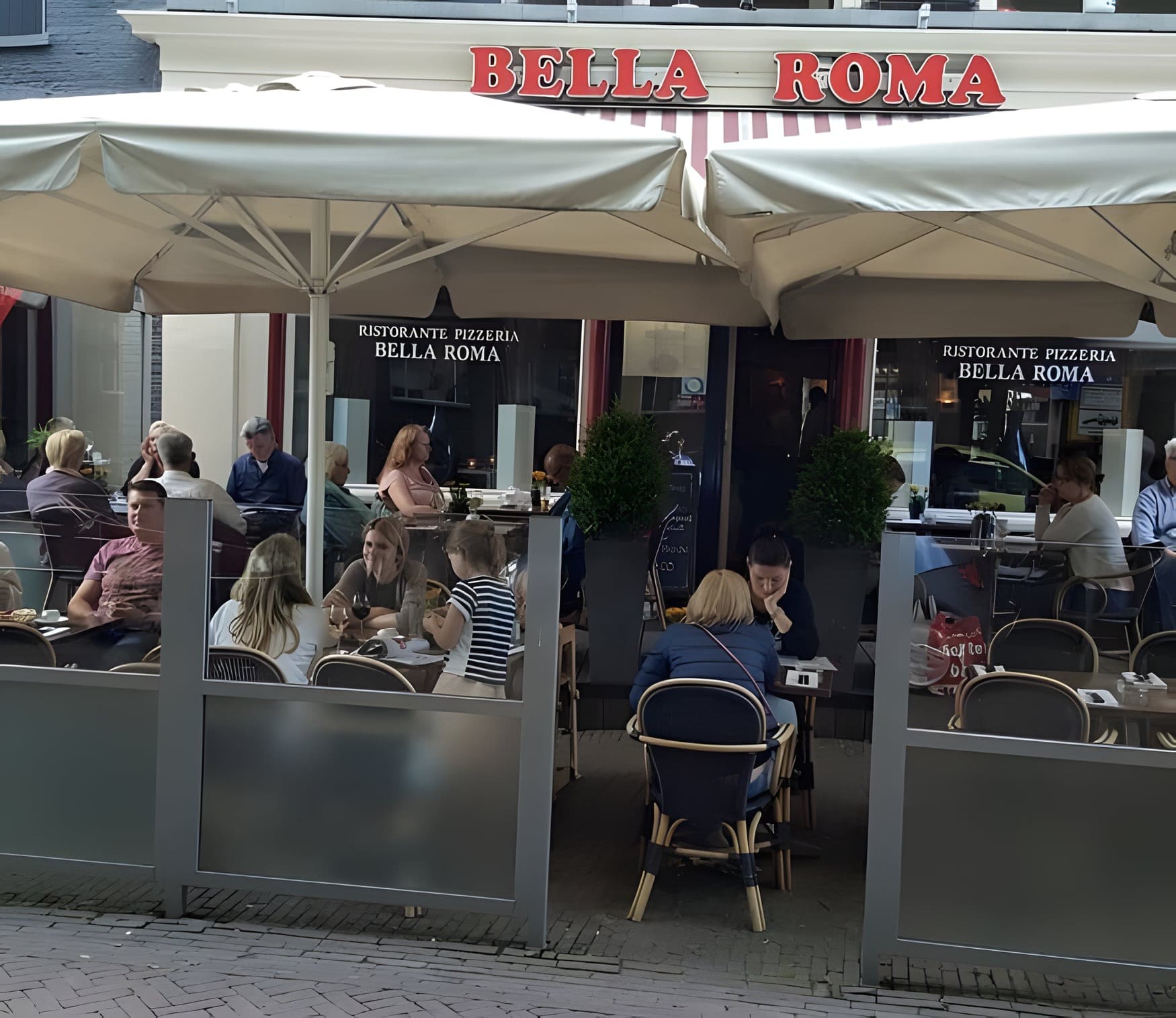 Het terras van Bella Roma aan de Brink onder de parasols