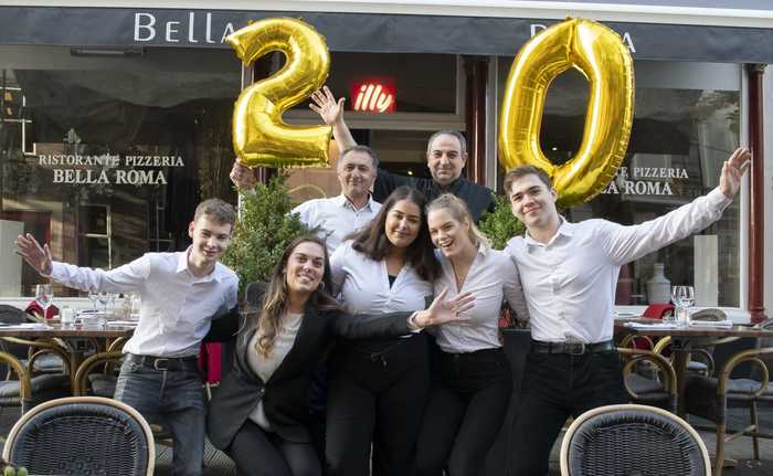 Het team van Bella Roma voor de gevel, met ballonnen